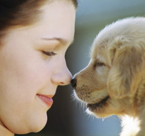 Woman Rubbing Noses with Puppy
